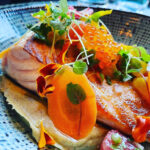 Saumon sur lit houmous au saté, pickles de carottes et oeufs de saumon